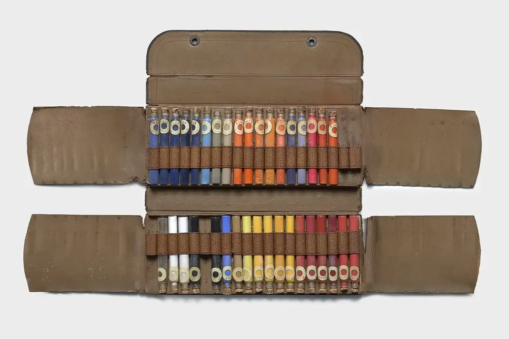 A fitted leather case holding rows of dry colour, one to a slot